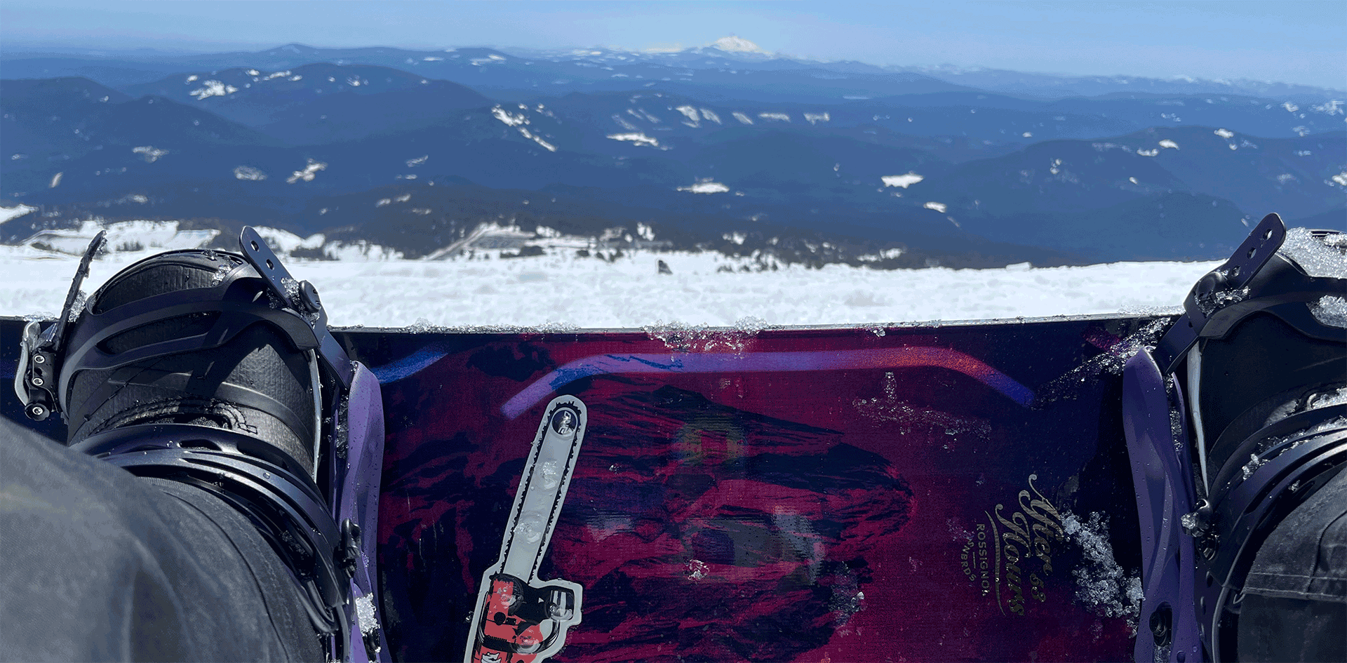 Image of my snowboard with my feet strapped-in, shot as I'm seated and about to ride-down. Mt Jefferson is in the distance. Shot from the top of Magic Mile at Timberline resort, in Government Camp, Oregon.